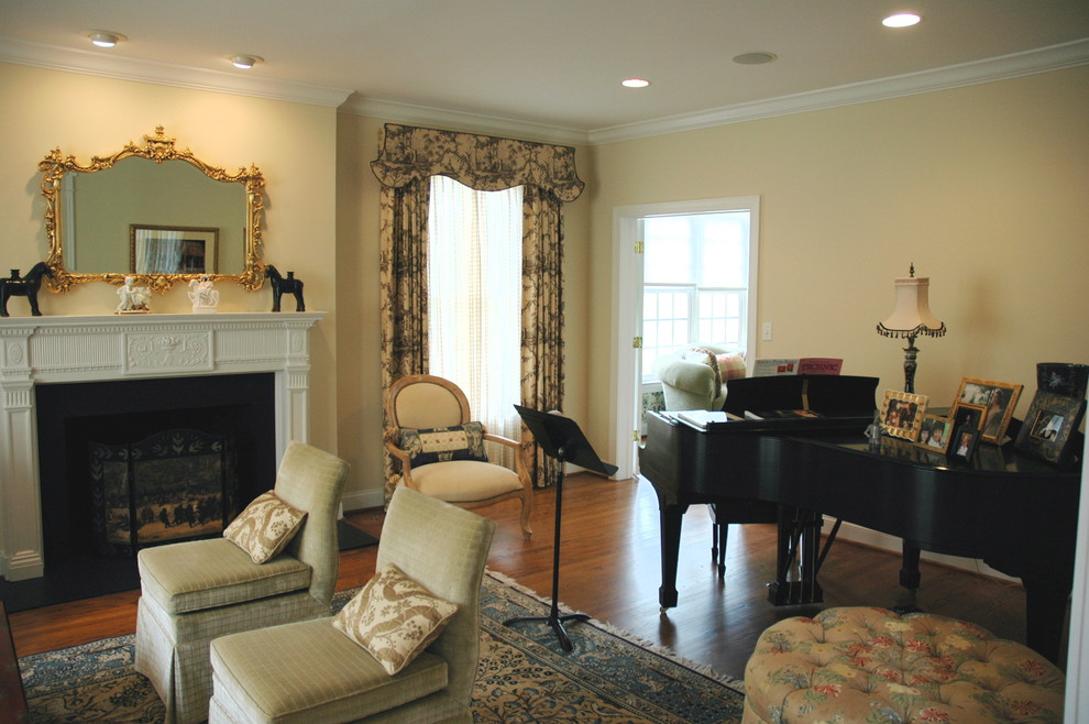 Example of a mid-sized classic enclosed medium tone wood floor and brown floor living room design in Philadelphia with a music area, yellow walls, a standard fireplace, a stone fireplace and no tv