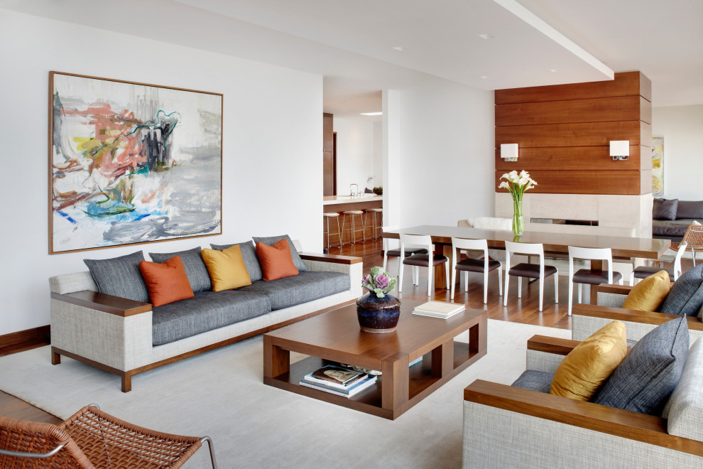 Esempio di un soggiorno minimal aperto con pareti bianche, pavimento in legno massello medio e pavimento marrone