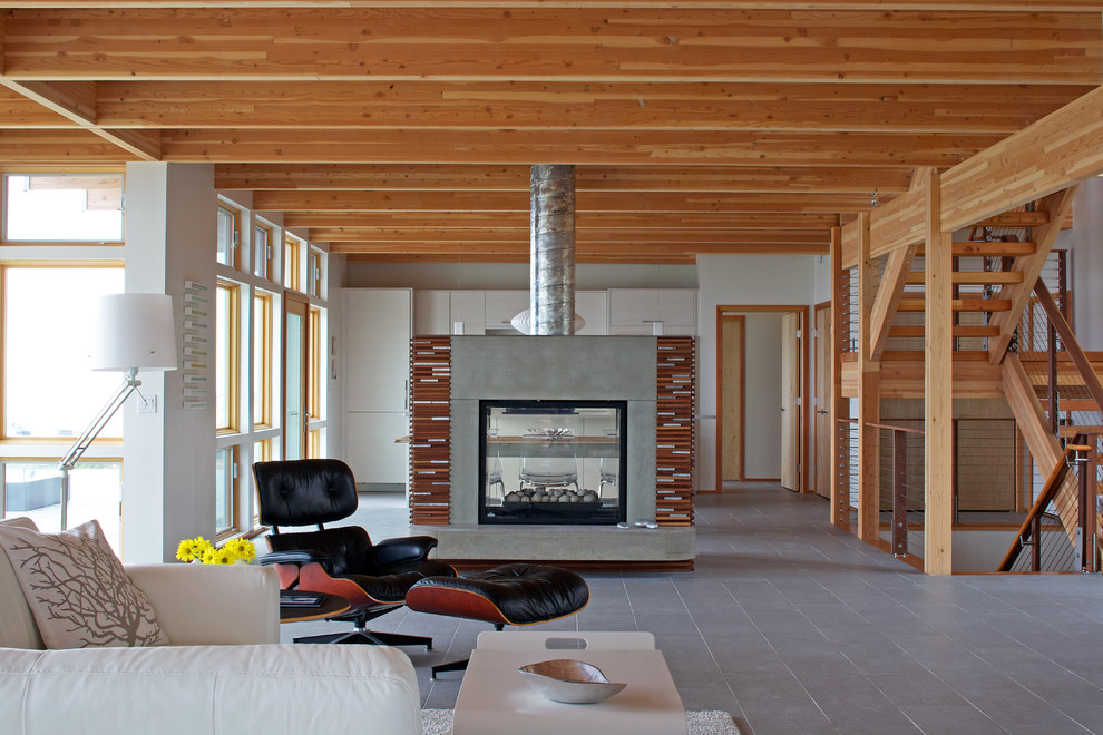 Cette photo montre un salon tendance ouvert et de taille moyenne avec une salle de réception, un mur blanc, un sol en carrelage de céramique, une cheminée double-face et un manteau de cheminée en béton.