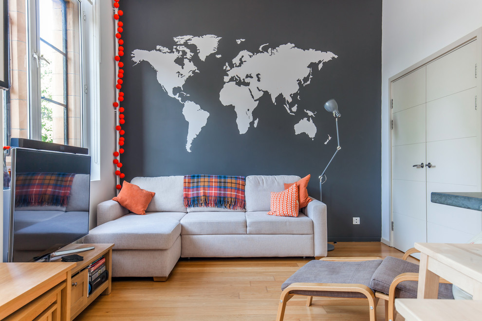 Example of a trendy enclosed medium tone wood floor and orange floor living room design in Sussex with multicolored walls, no fireplace and a tv stand