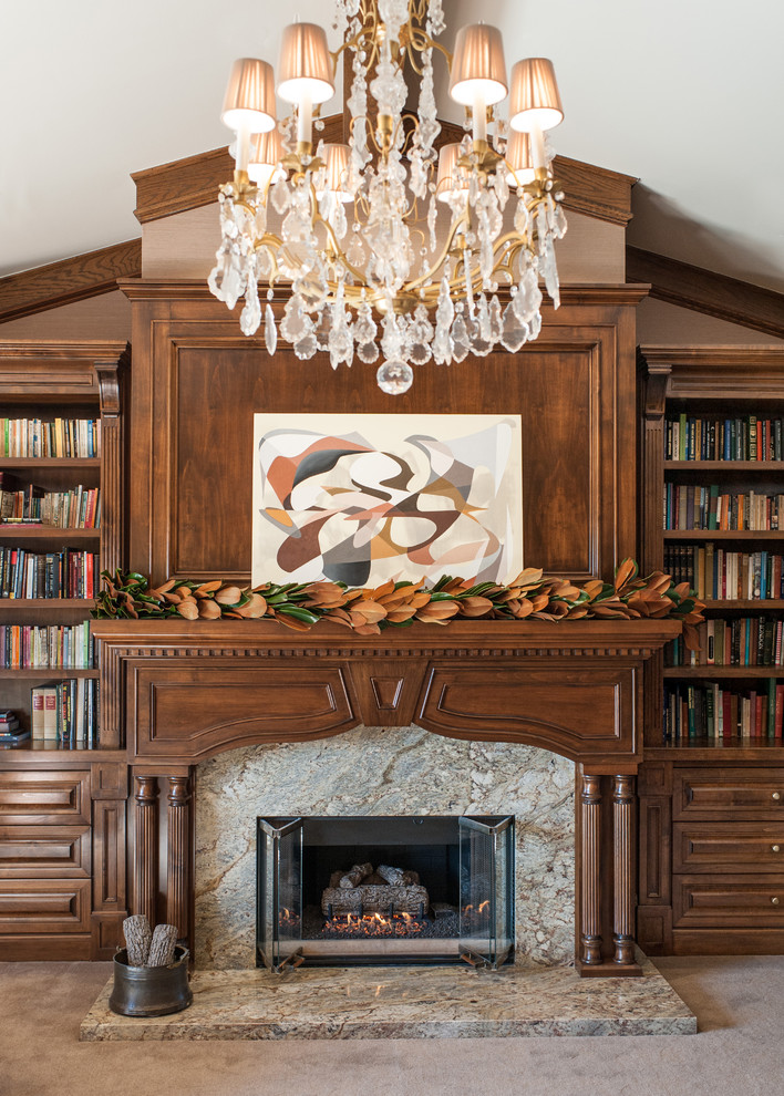 Imagen de biblioteca en casa clásica sin televisor con paredes beige, moqueta, todas las chimeneas y marco de chimenea de piedra