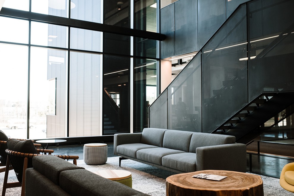 Esempio di un soggiorno design con pareti grigie, pavimento in cemento e pavimento nero