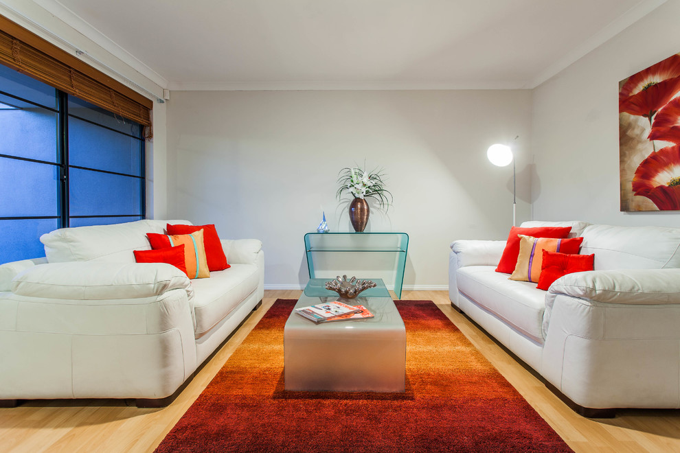 Immagine di un soggiorno design con pareti grigie e pavimento in legno massello medio