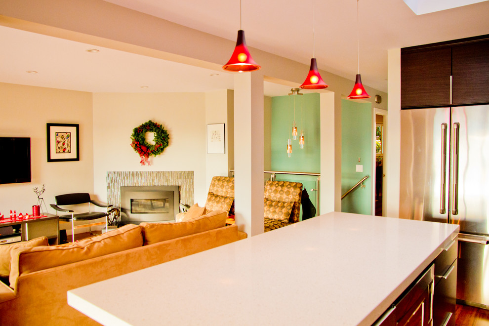 Mittelgroßes, Offenes Modernes Wohnzimmer mit grüner Wandfarbe, braunem Holzboden, Kamin, gefliester Kaminumrandung und TV-Wand in San Francisco
