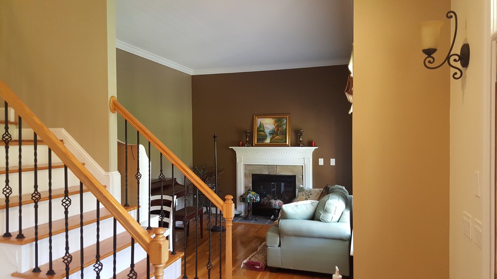 Mid-sized formal and enclosed medium tone wood floor living room photo in Raleigh with multicolored walls, a standard fireplace, a plaster fireplace and no tv