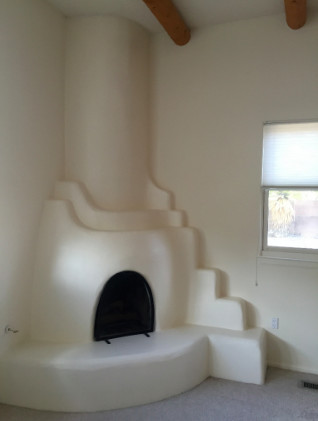 Idées déco pour un salon sud-ouest américain de taille moyenne avec un mur blanc, moquette, une cheminée d'angle, un manteau de cheminée en plâtre et un sol beige.