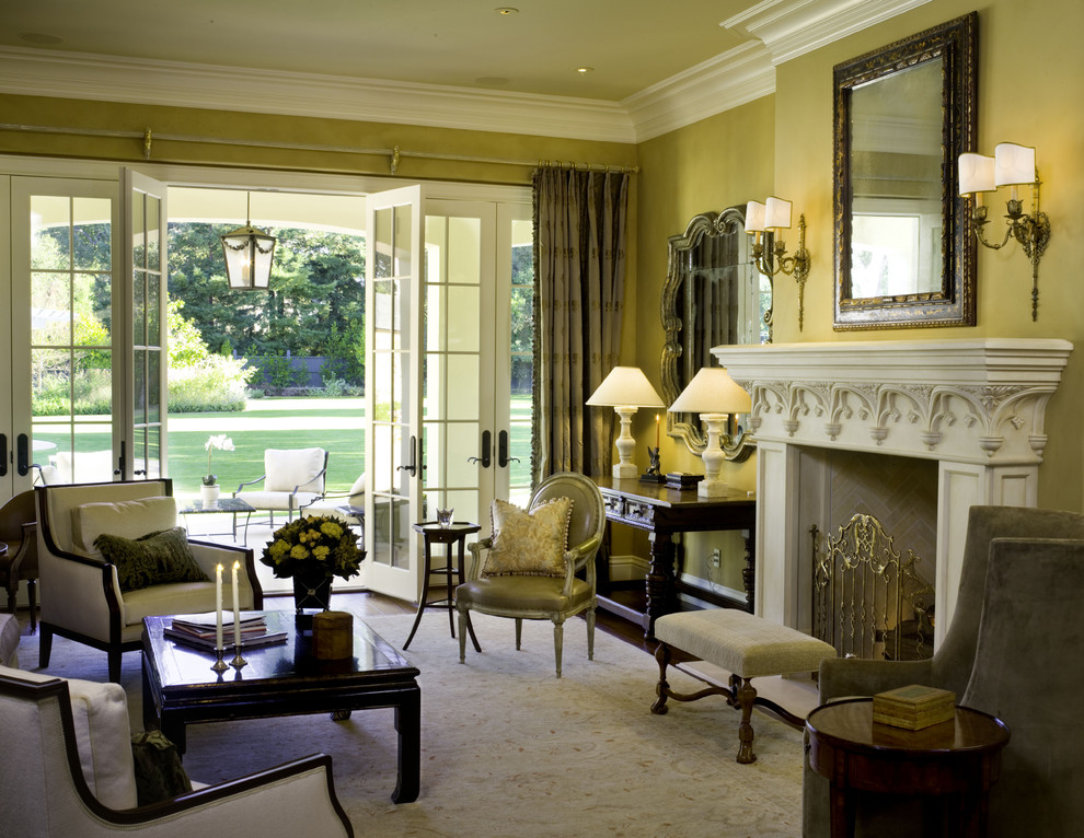 Immagine di un grande soggiorno tradizionale con pareti gialle e camino classico