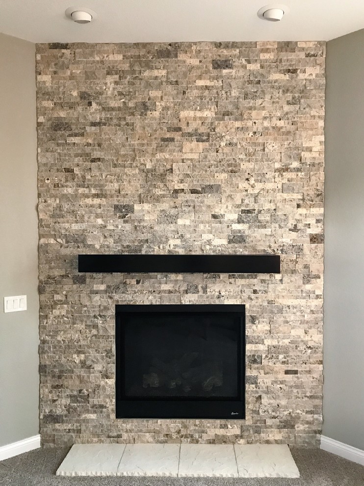 ミルウォーキーにあるトランジショナルスタイルのおしゃれな応接間 (グレーの壁、カーペット敷き、コーナー設置型暖炉、石材の暖炉まわり、テレビなし、グレーの床) の写真