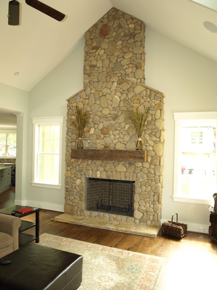 シャーロットにある高級な中くらいなトラディショナルスタイルのおしゃれなLDK (標準型暖炉、石材の暖炉まわり、テレビなし、グレーの壁、濃色無垢フローリング) の写真