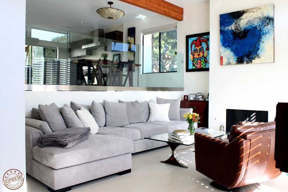 На фото: двухуровневая гостиная комната среднего размера в современном стиле с белыми стенами, ковровым покрытием, стандартным камином и фасадом камина из штукатурки без телевизора