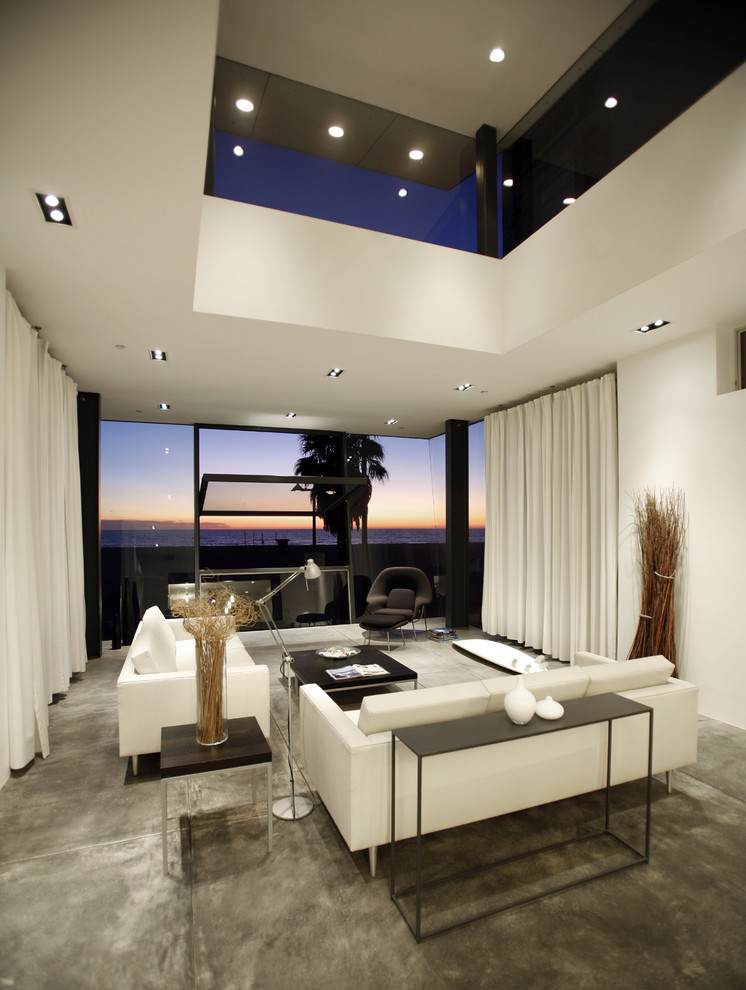 Стильный дизайн: гостиная комната в стиле модернизм с белыми стенами и бетонным полом - последний тренд