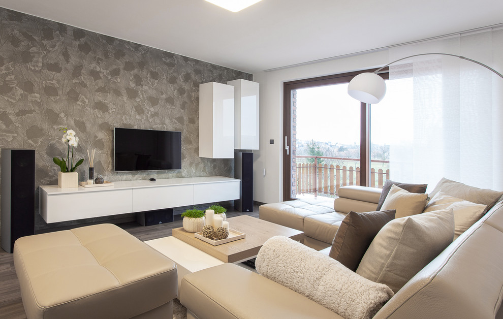 Esempio di un grande soggiorno moderno aperto con sala formale, pareti bianche, pavimento in legno massello medio, nessun camino e TV a parete