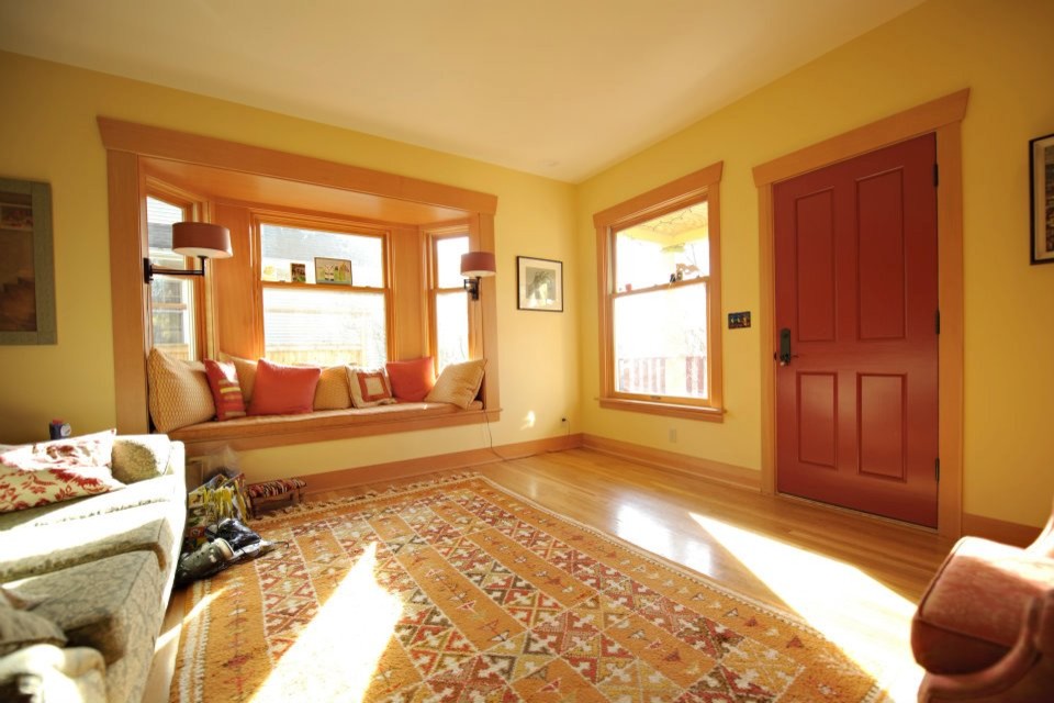 Immagine di un soggiorno chic di medie dimensioni e chiuso con pareti gialle e pavimento in legno massello medio