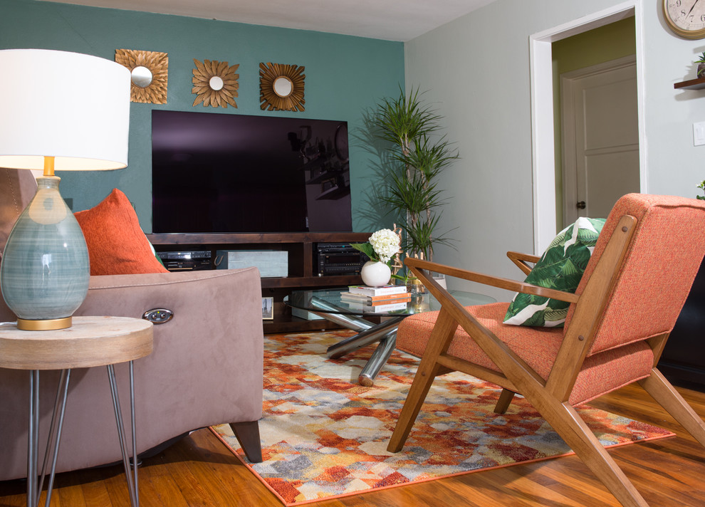 Diseño de salón cerrado moderno pequeño sin chimenea con paredes azules, suelo de madera en tonos medios, televisor independiente y suelo naranja