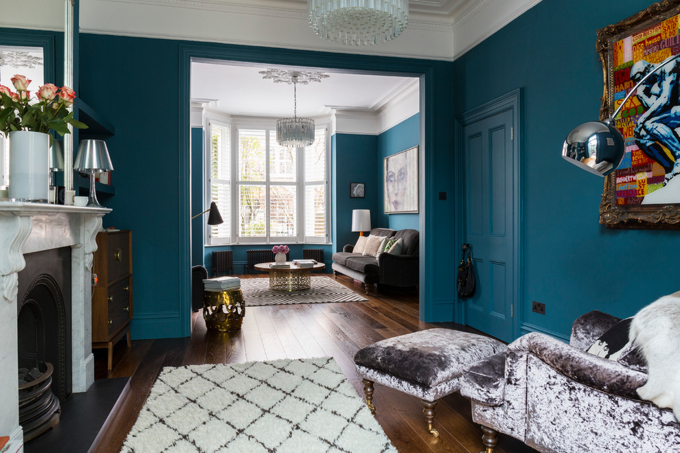 Diseño de salón abierto tradicional renovado con paredes azules, suelo de madera en tonos medios y todas las chimeneas