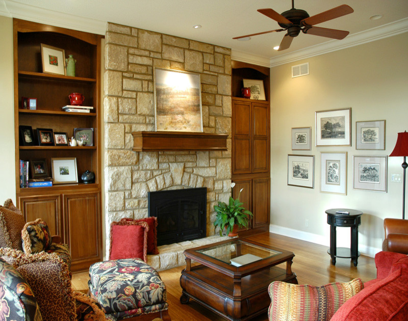 Inspiration för ett vintage vardagsrum, med beige väggar, mellanmörkt trägolv, en standard öppen spis och en spiselkrans i sten