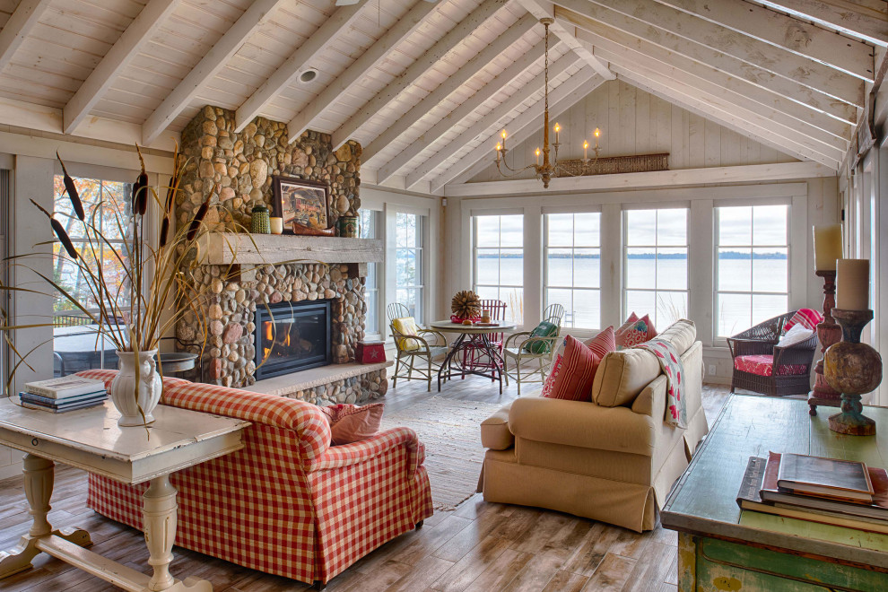 Offenes Uriges Wohnzimmer mit braunem Holzboden, Kamin, braunem Boden, gewölbter Decke und Holzwänden in Minneapolis