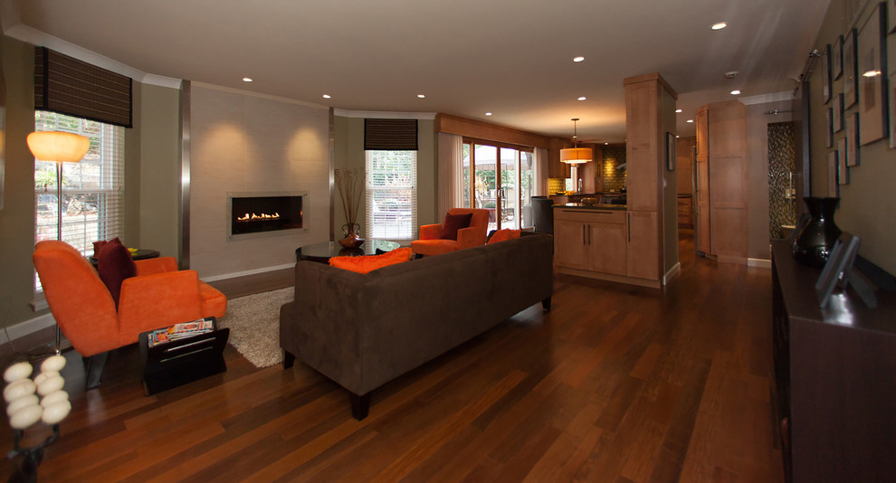 Large contemporary open plan living room in St Louis with green walls, medium hardwood flooring and a ribbon fireplace.