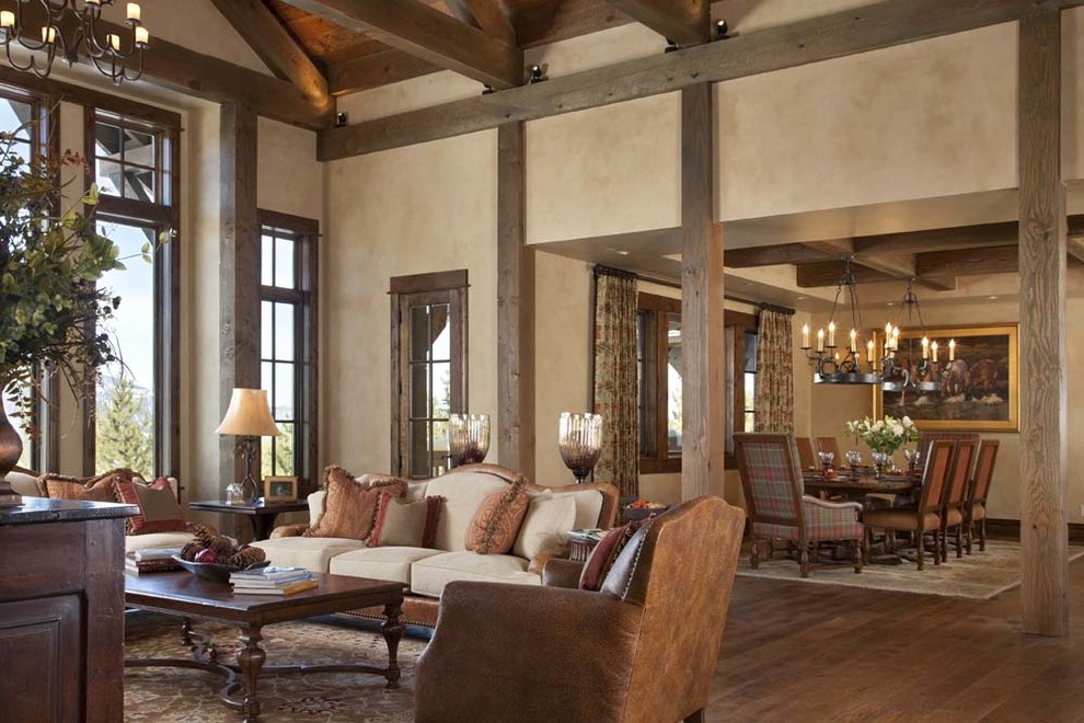 Ejemplo de salón abierto rural con paredes beige, suelo de madera en tonos medios y cortinas