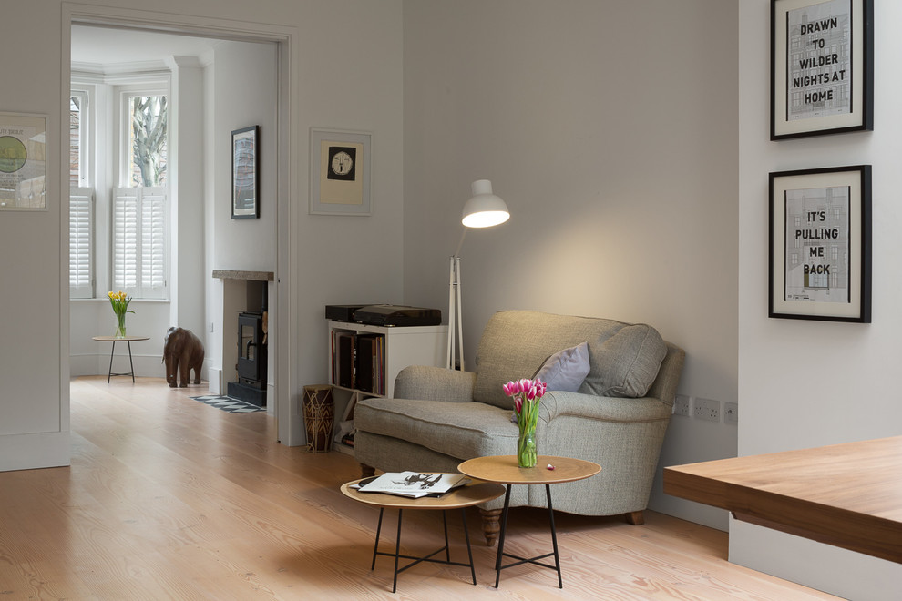 Imagen de salón abierto tradicional renovado grande con paredes blancas, suelo de madera clara y estufa de leña