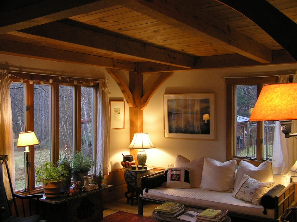 Cette image montre un petit salon craftsman ouvert avec une salle de réception, un mur beige, parquet clair, un poêle à bois, un manteau de cheminée en métal et aucun téléviseur.