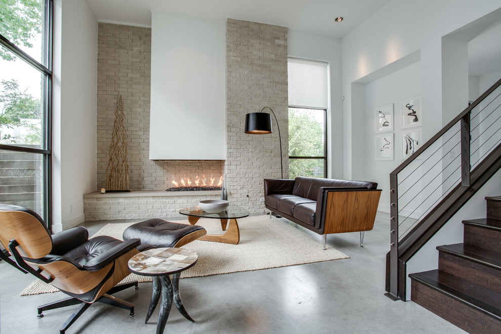 Idées déco pour un salon contemporain avec sol en béton ciré, un mur blanc et un escalier.