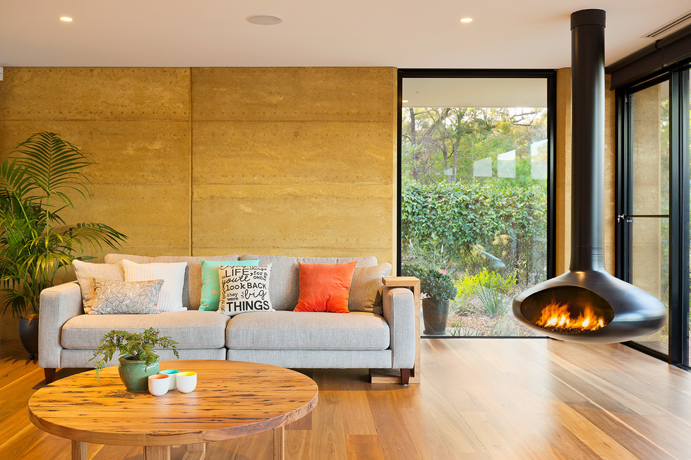 This is an example of a contemporary formal open plan living room feature wall in Melbourne with a hanging fireplace.