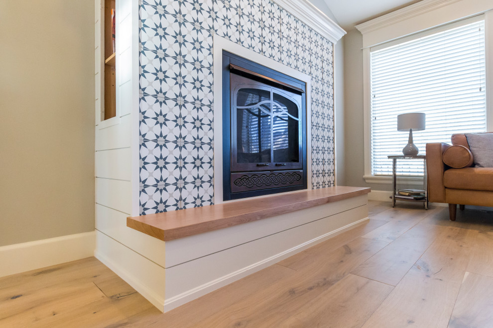 Repräsentatives, Fernseherloses Modernes Wohnzimmer mit grauer Wandfarbe, Sperrholzboden, Kamin, gefliester Kaminumrandung und beigem Boden in Boise