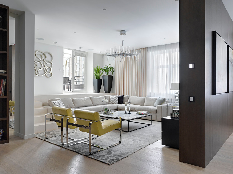 Стильный дизайн: парадная, открытая, объединенная гостиная комната в современном стиле с белыми стенами и светлым паркетным полом - последний тренд