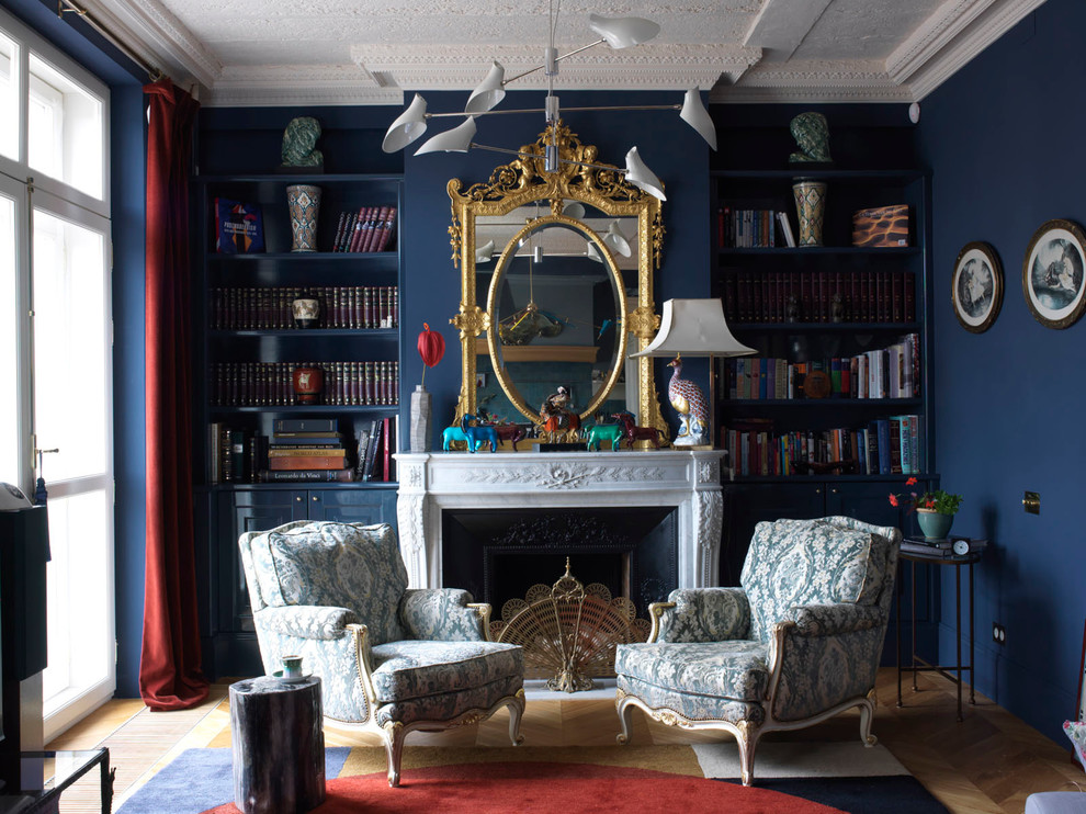 Foto di un soggiorno chic con pareti blu e camino classico