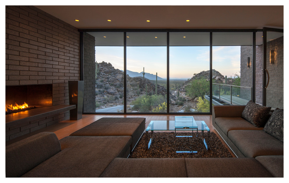 Living room - large contemporary formal and enclosed medium tone wood floor living room idea in Phoenix with a wood stove, a brick fireplace and no tv