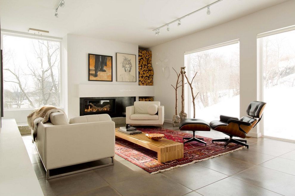 Cette image montre un salon design de taille moyenne avec une salle de réception, un mur blanc, sol en béton ciré, une cheminée standard et un manteau de cheminée en métal.