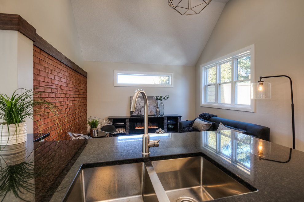 Example of an urban open concept medium tone wood floor living room design in Toronto with gray walls, a standard fireplace and a stone fireplace