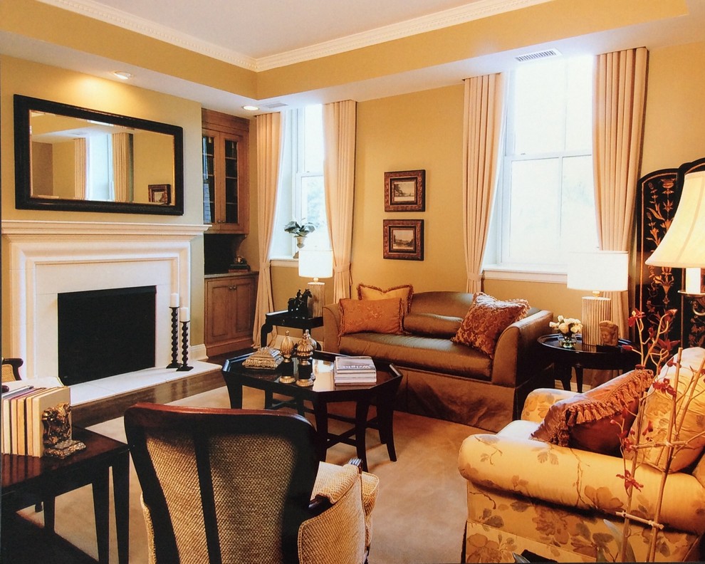 Exempel på ett mellanstort klassiskt separat vardagsrum, med ett finrum, gula väggar, kalkstensgolv, en standard öppen spis, en spiselkrans i sten och en dold TV