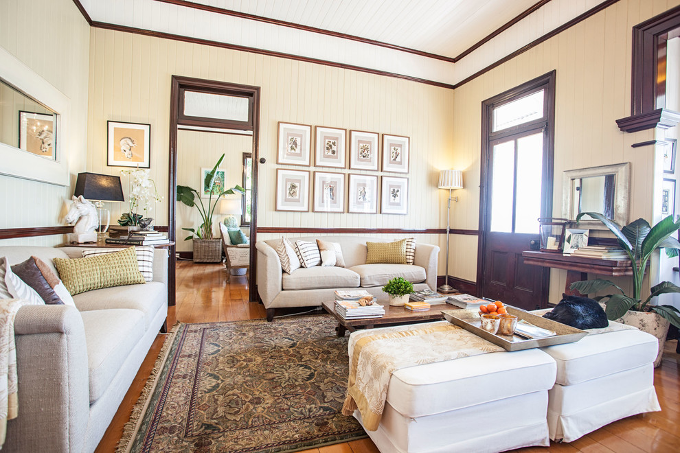 Diseño de salón cerrado clásico sin chimenea y televisor con paredes beige y suelo de madera en tonos medios