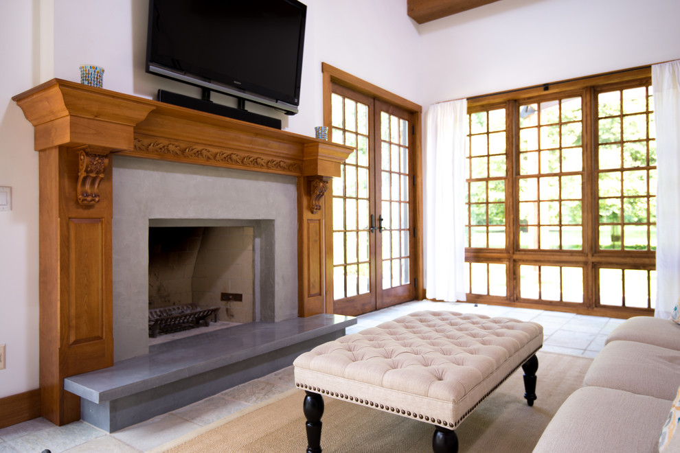 Идея дизайна: открытая гостиная комната среднего размера в стиле неоклассика (современная классика) с белыми стенами, полом из известняка, стандартным камином, фасадом камина из бетона, телевизором на стене и бежевым полом