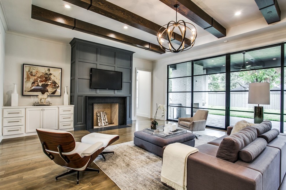 Klassisches Wohnzimmer mit weißer Wandfarbe, braunem Holzboden, Kamin, TV-Wand und braunem Boden in Dallas