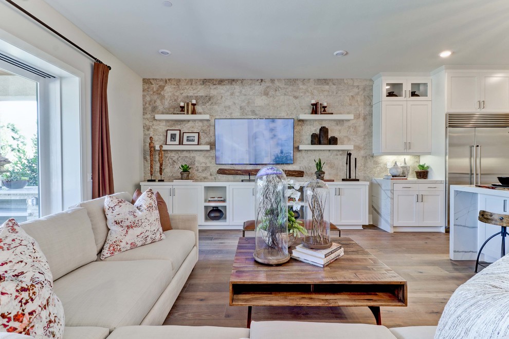 Offenes Klassisches Wohnzimmer mit weißer Wandfarbe, braunem Holzboden, TV-Wand und braunem Boden in Orange County