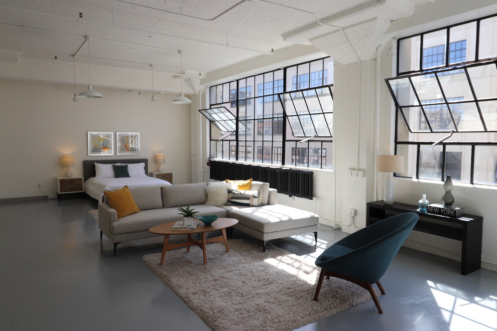 Imagen de salón abierto urbano con paredes blancas, suelo de cemento y suelo gris