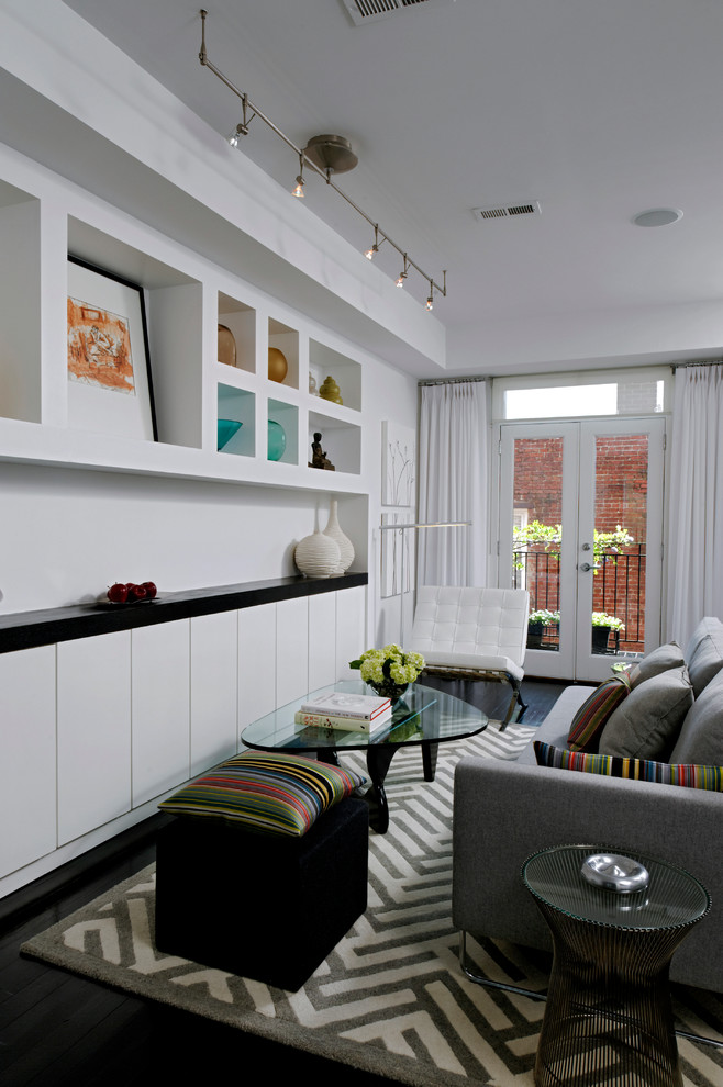 Aménagement d'un petit salon contemporain avec parquet foncé, un mur blanc et éclairage.