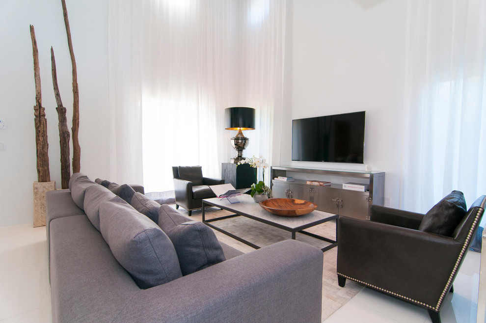 На фото: гостиная комната в современном стиле с белыми стенами и телевизором на стене без камина с