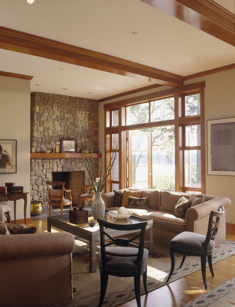 Klassisches Wohnzimmer mit beiger Wandfarbe, Kamin und Kaminumrandung aus Stein in Seattle