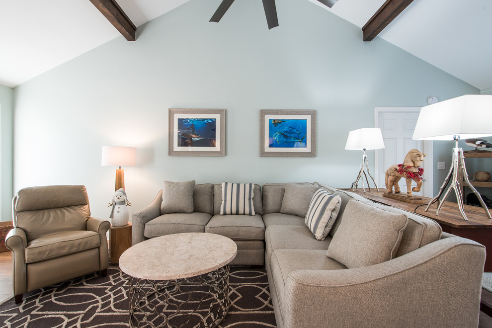 Diseño de salón abierto de estilo de casa de campo de tamaño medio con paredes azules, suelo de madera en tonos medios, todas las chimeneas, marco de chimenea de ladrillo y televisor colgado en la pared