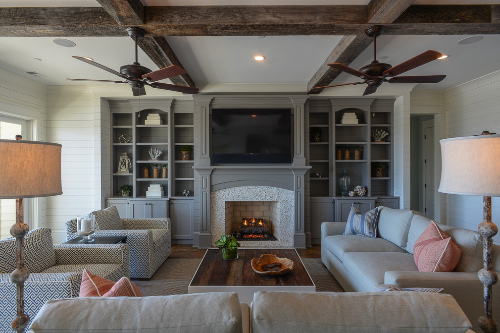 This is an example of a medium sized coastal formal enclosed living room in Charleston with white walls, medium hardwood flooring, a standard fireplace, a stone fireplace surround, a wall mounted tv and brown floors.