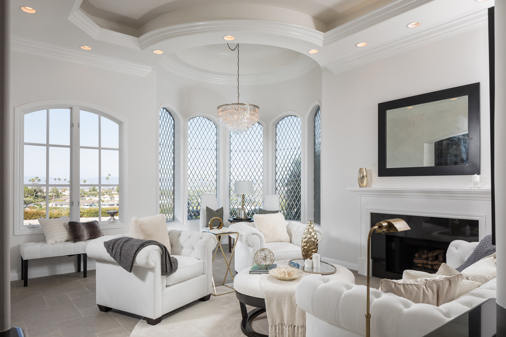 Repräsentatives Mediterranes Wohnzimmer mit weißer Wandfarbe, Kamin und grauem Boden in Orange County