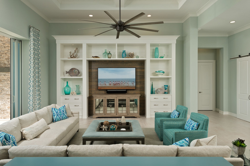 На фото: гостиная комната в морском стиле с синими стенами, телевизором на стене и бежевым полом