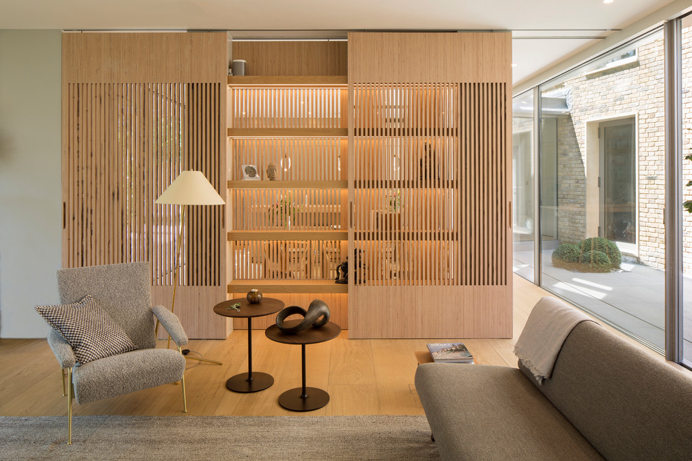 Imagen de salón abierto moderno con paredes blancas y suelo de madera clara