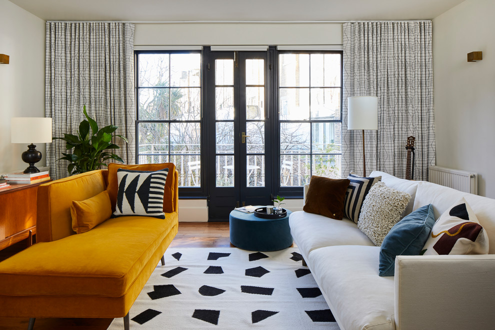 Example of a mid-sized mid-century modern loft-style laminate floor and brown floor living room design in London with no fireplace and white walls