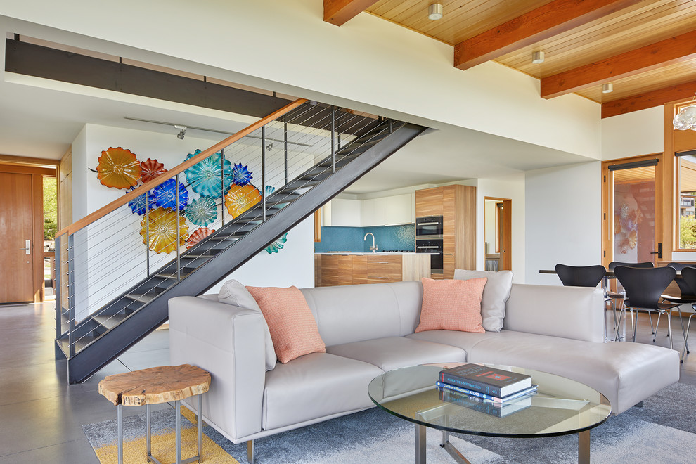 Offenes Modernes Wohnzimmer mit weißer Wandfarbe, Betonboden und grauem Boden in Seattle