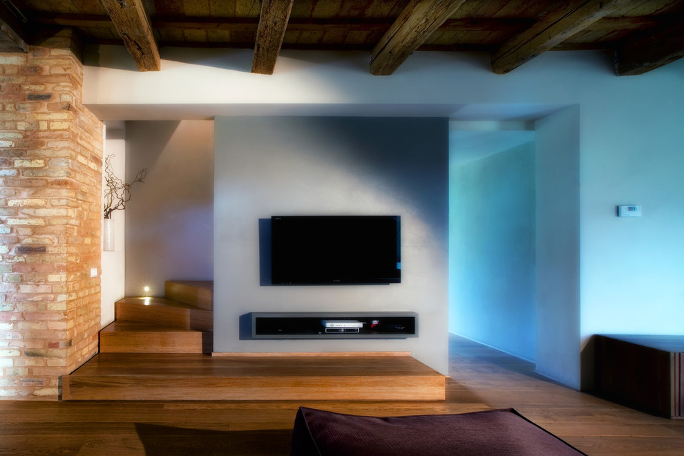 Источник вдохновения для домашнего уюта: парадная, открытая гостиная комната среднего размера в стиле модернизм с серыми стенами, паркетным полом среднего тона и телевизором на стене без камина